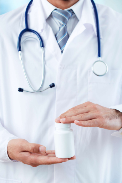 دکتری که یک بسته قرص در دست دارد.